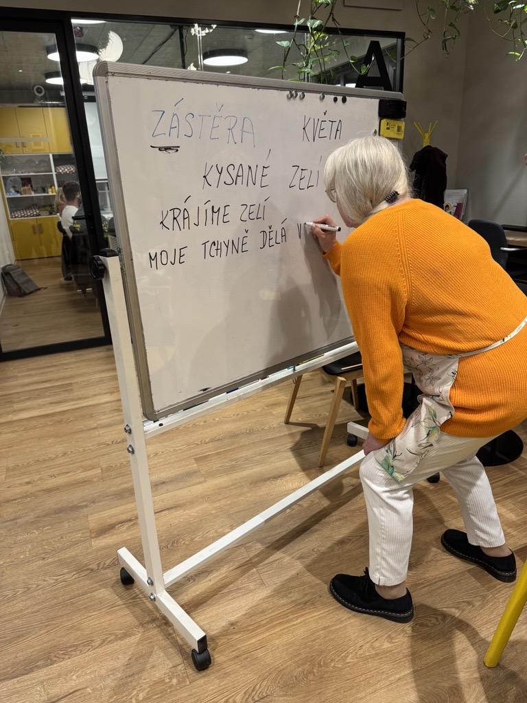 Teacher writing Czech words on a classroom board