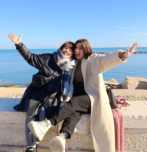 Two smiling members of the community sitting by the sea